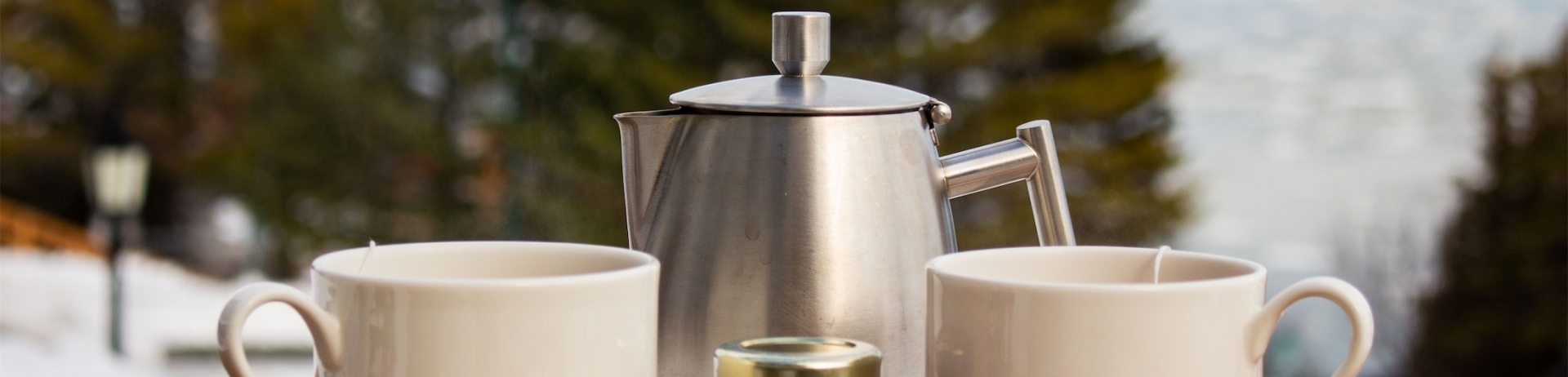 Deux tasses à côté d'un thé en métal