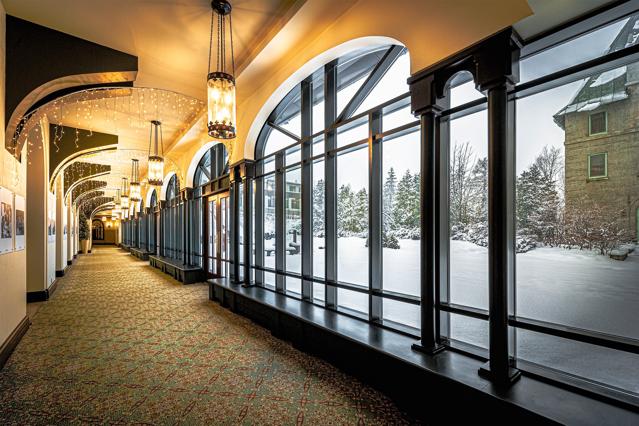 hallway with large windows leading out to the property grounds