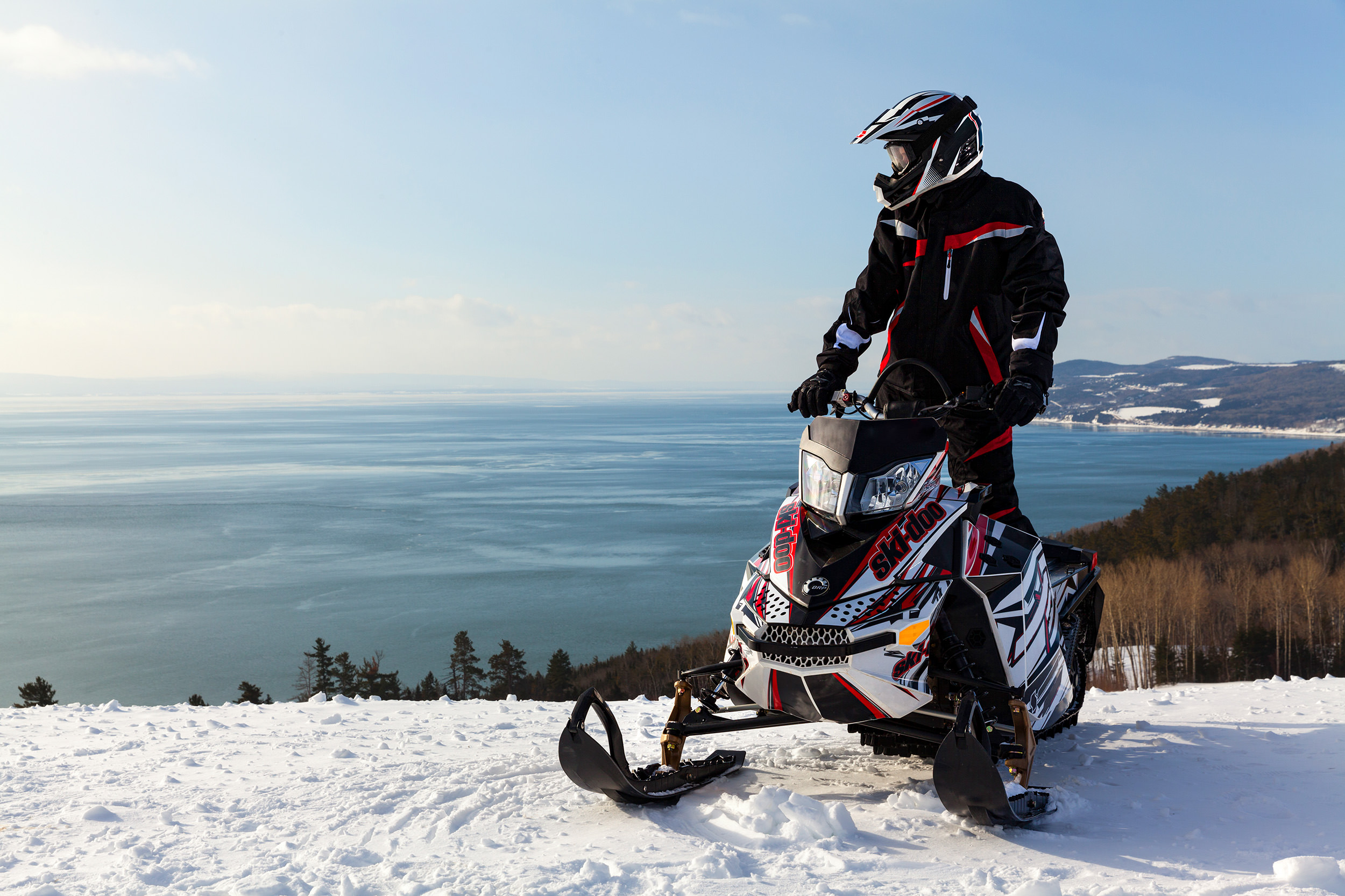 Homme en motoneige regardant vers l'eau