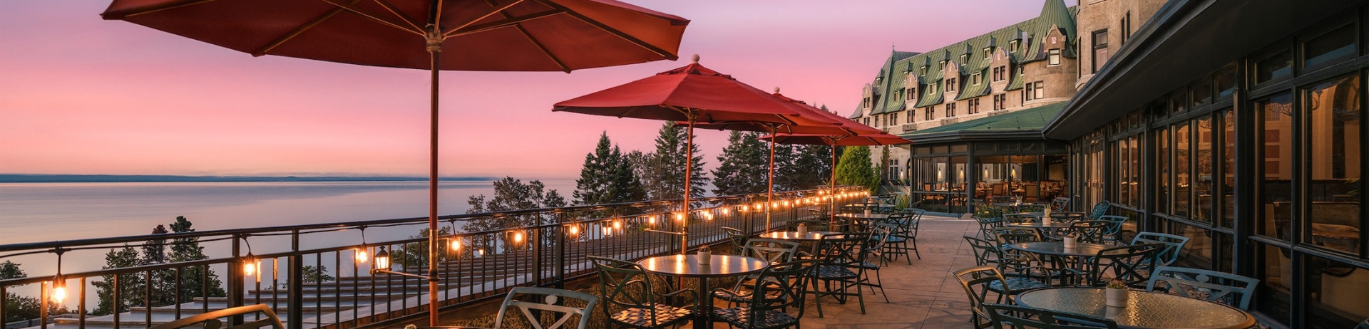 dining area with red umbrellas lit up at sunset