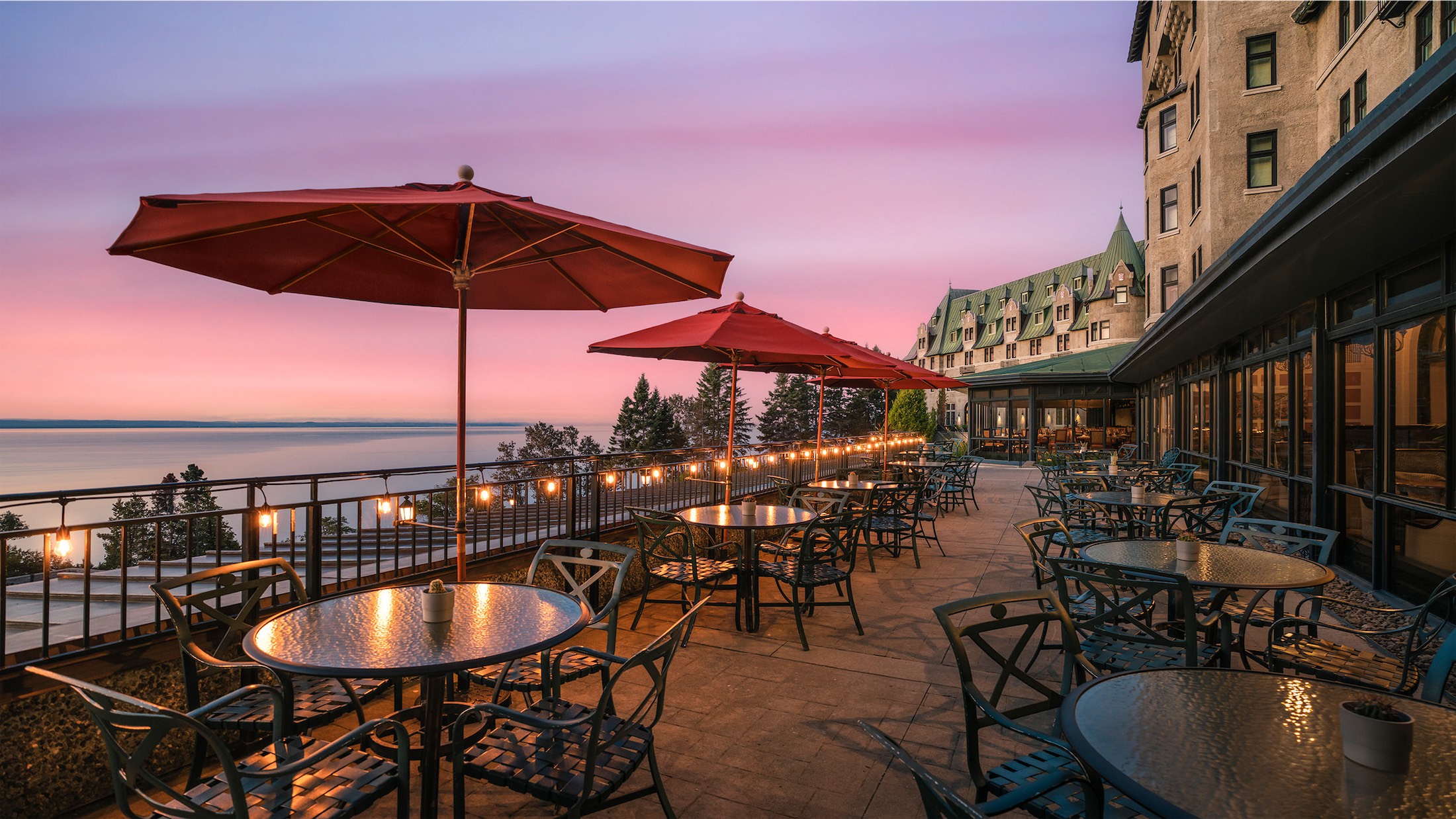 dining area with red umbrellas lit up at sunset