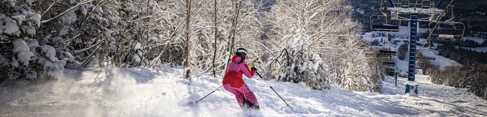 woman skiing down slope under ski lift