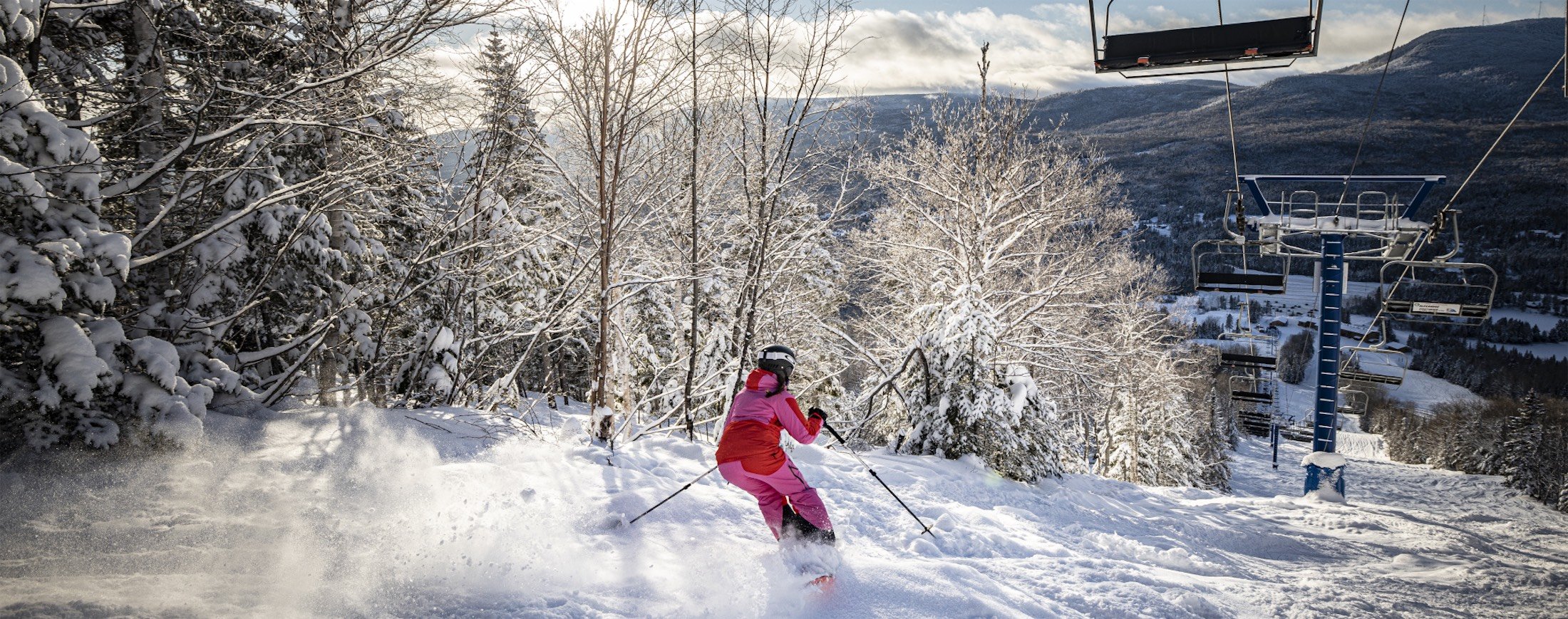 woman skiing down slope under ski lift