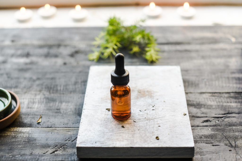 small bottle with dropper on a wooden cutting board
