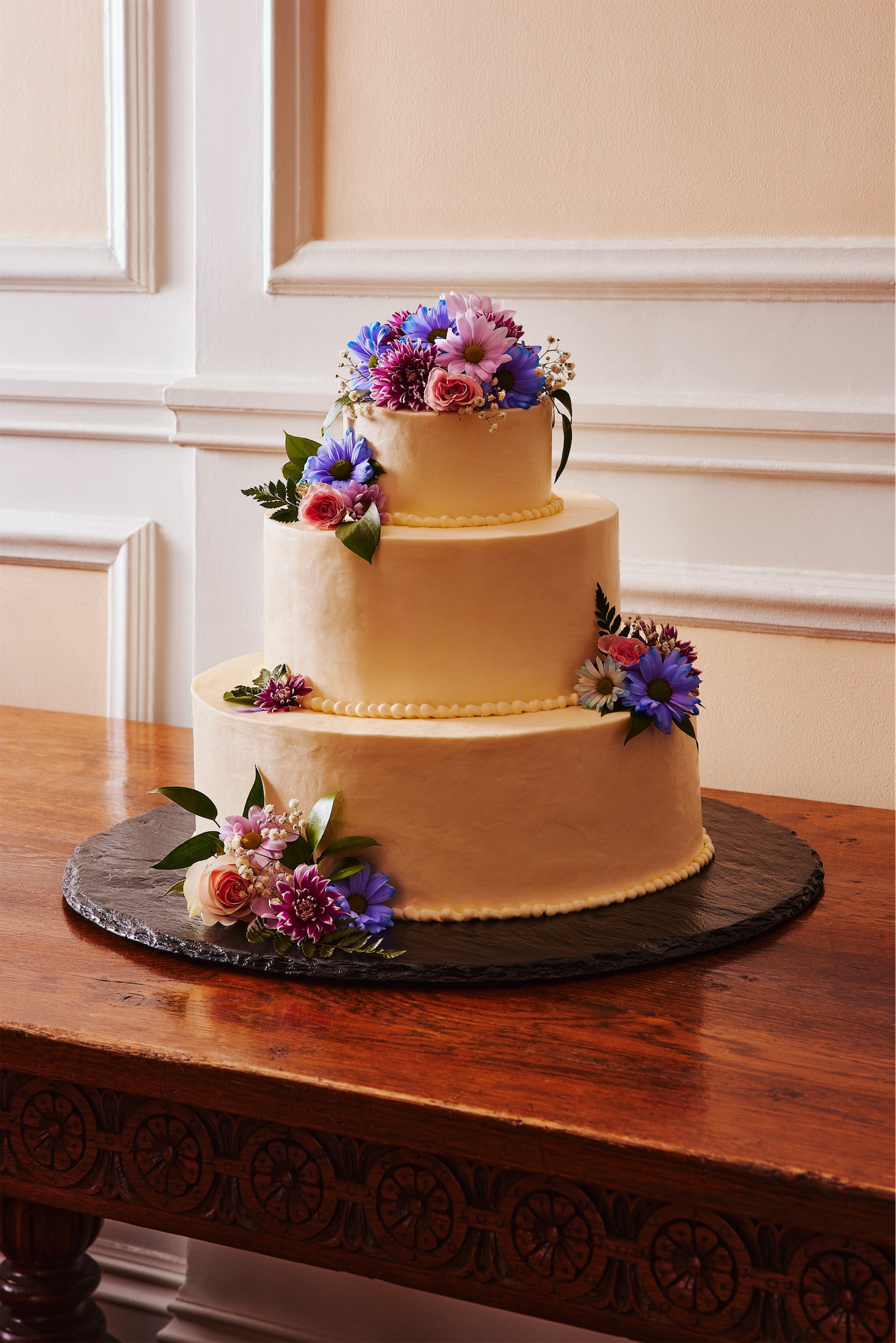 wedding cake with purple and pink icing flowers