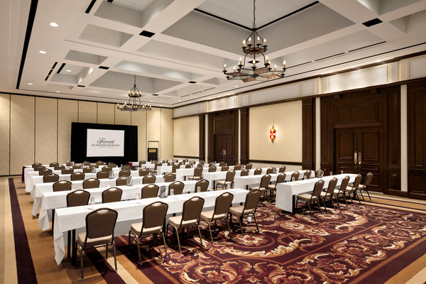 room set up with rows of tables and chairs and a podium in the front