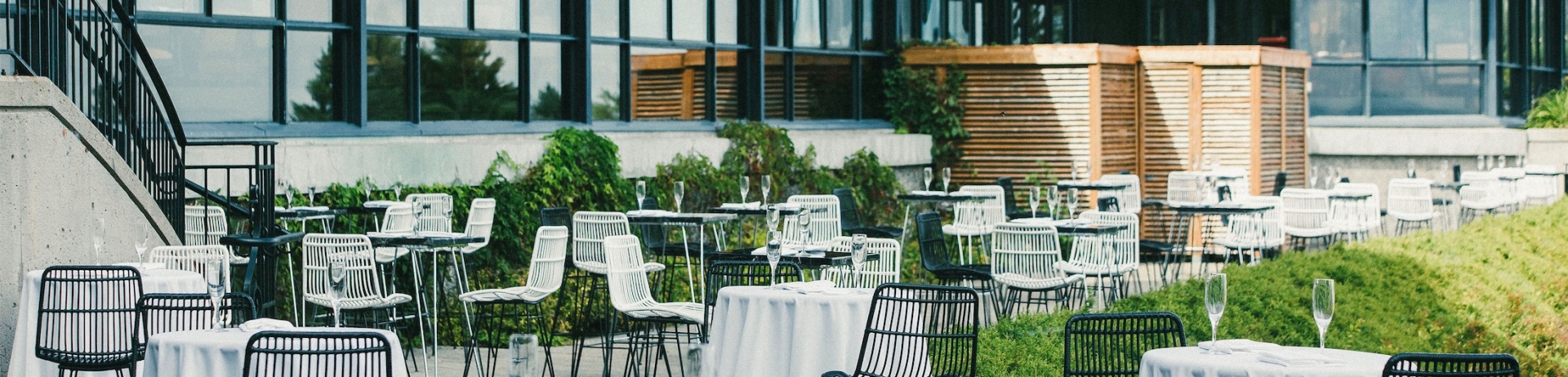 Zone de rassemblement extérieur avec de petites tables rondes et des chaises hautes