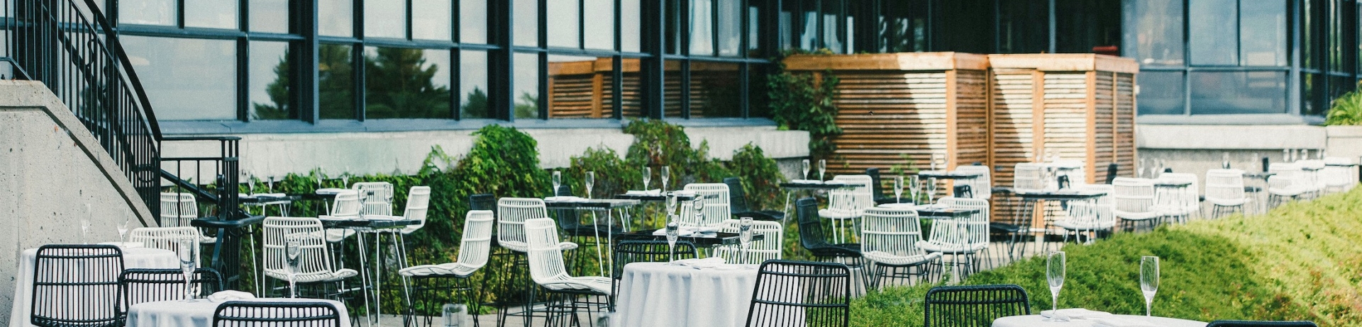 outdoor gathering area with small round tables and high chairs