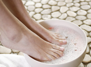 personne trempant les pieds dans l'eau