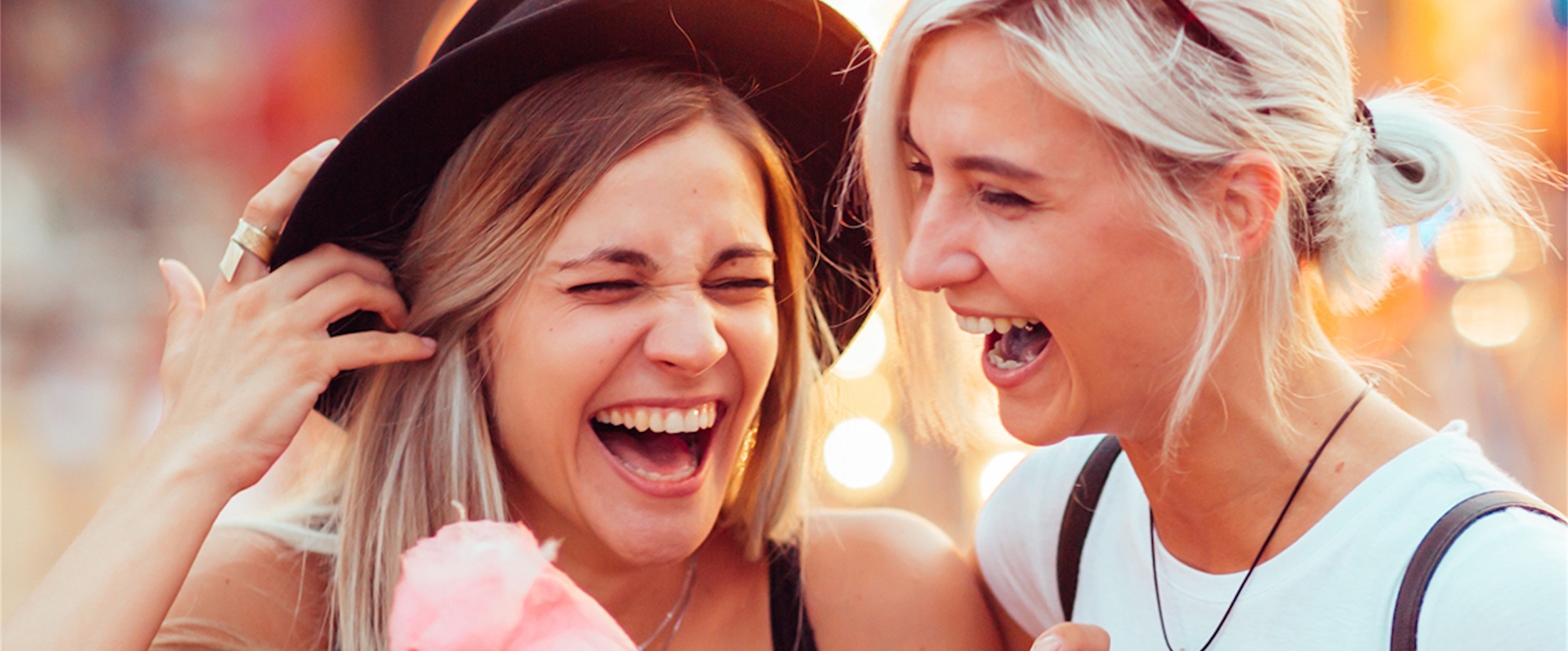 two women walking and eating cotton candy